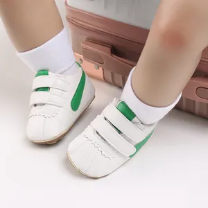 Primer plano de zapatos de bebé blancos y verdes con suela blanda para caminar