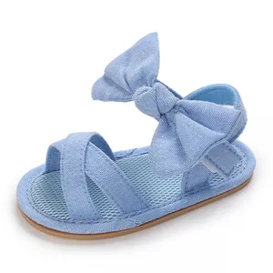 Detail view of light blue baby girl sandals with large bow and soft rubber sole