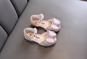 Detailed view of pink girls' princess shoes decorated with rhinestones, pearls and bows
