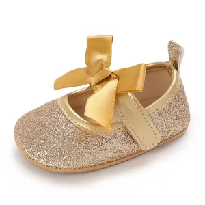 Detail view of gold glitter baby princess walking shoes with a large satin bow