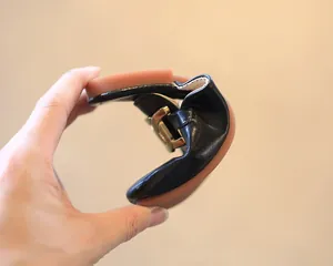 Flexible schwarze Leder-Hausschuhe für Mädchen mit einer goldenen Metallschnalle.