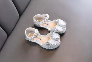 Detailed view of silver glitter girls princess shoes with butterfly and pearl accents.