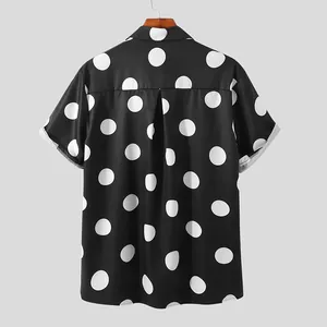 Detailed back view of a men's black short-sleeved shirt with large white polka dots