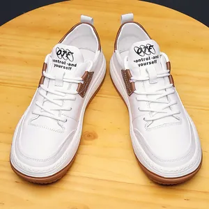 Lässige weiße Leder-Sneaker mit braunen Akzenten auf einer runden Holzoberfläche