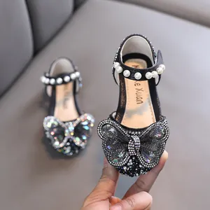 Elegant black girls princess shoes featuring a large rhinestone butterfly and pearl strap
