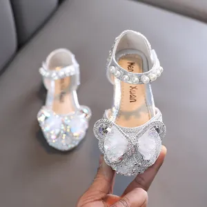 Elegant silver glitter girl's princess shoes with a large butterfly bow and decorative pearls