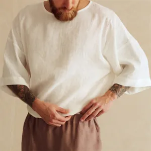 Detalle de una camisa de lino blanco para hombre con cuello redondo y media manga