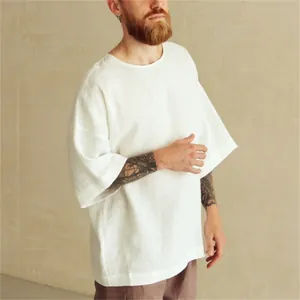 Hombre que viste una camisa blanca minimalista de lino con cuello redondo y media manga