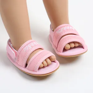 Detailed view of pink breathable mesh baby sandals featuring flexible soft soles on a doll
