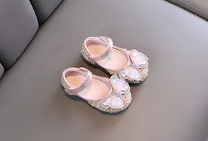 Primer plano de zapatos de princesa rosas con lazos de pedrería y malla para niñas