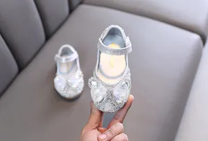 Primer plano de zapato de princesa plateado para niña con lazo de diamantes y malla
