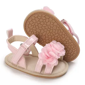 Vue détaillée de sandales roses pour bébé avec fleur en tissu et semelle en gomme