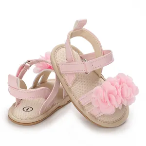 Gros plan de sandales roses pour bébé avec grande fleur en tissu et cuir verni