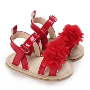 Détail de sandales rouges pour bébé fille avec décoration florale en maille 3D.