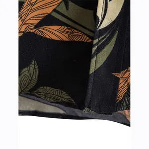 Close-up view of the tropical leaf print and hem stitching on men's black cotton shirt