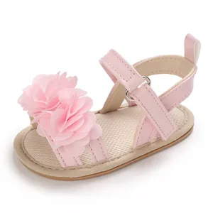 Détail d'une sandale d'été rose pour bébé fille avec une grande fleur décorative