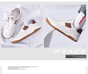 Gedetailleerd zicht op witte rundleer herensneakers met bruine accenten en PEACE motief