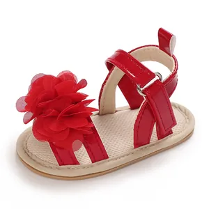 Vue détaillée de sandales rouges pour bébé fille avec grande fleur en mousseline et velcro