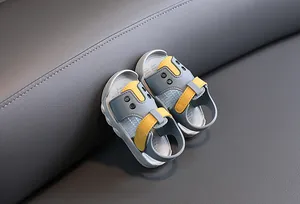 Close-up detail of grey and yellow baby summer sandals featuring anti-slip soft soles and straps