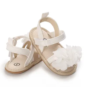 Vue détaillée de sandales blanches pour bébé avec fleur en maille et attache velcro.