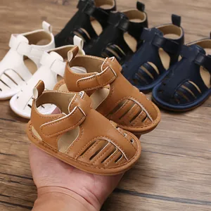 Sandalias marrones transpirables para bebé con suela blanda antideslizante y cierre velcro en mano