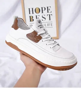 Close-up van witte leren herensneaker met bruine accenten en rubberen zool
