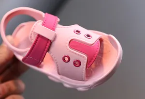 Close-up of lightweight pink baby summer sandal with soft sole and fuchsia velcro strap