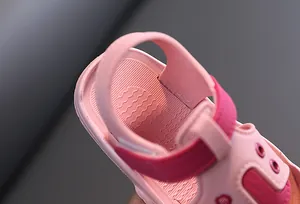 Close-up of pink baby toddler sandals with soft sole and velcro strap detail.