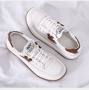 Gedetailleerd bovenaanzicht van stijlvolle witte leren herensneakers met bruine accenten