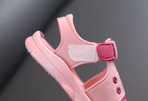 Detailed view of pink toddler sandal featuring adjustable velcro strap and soft heel support