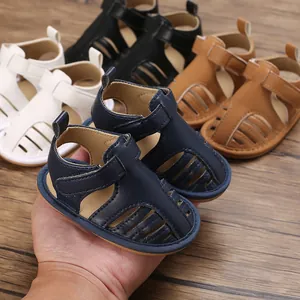 Primer plano de sandalias para bebé azul marino transpirables con velcro sobre madera