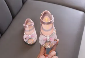 Vista detallada de zapatos de princesa rosas para niñas con perlas y un gran lazo de malla fina
