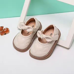 Detailed view of beige baby girl princess shoes featuring heart stitching and bow accents