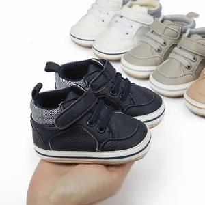 Detailed view of soft-sole navy baby toddler shoes held in hand for size reference