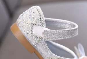 Vista detallada de los zapatos de princesa plateados para niñas con perlas y pedrería