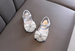 Detailansicht von funkelnden silbernen Prinzessinnenschuhen für Mädchen mit Perlschleife