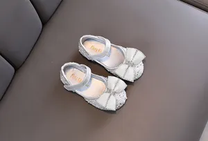 Detailansicht silberne Mädchen Prinzessin Schuhe mit Perlenbogen und funkelnden Strasssteinen