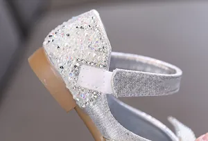 Detaillierte Nahaufnahme silberner Prinzessinnenschuhe für Mädchen mit Strass und Perlen