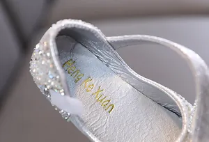 Nahaufnahme der glitzernden Strass-Details an silbernen Mädchen-Prinzessin-Schuhen