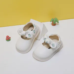 Detailed view of white floral bow princess shoes for baby girls with soft spring soles.