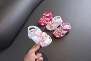 Détail de sandales pour fillettes avec fleurs et semelles souples antidérapantes