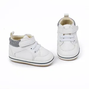 Nahaufnahme weißer Baby-Lauflernschuhe für Jungen mit weicher, rutschfester Sohle.