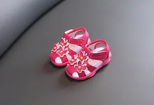 Détails d'une paire de sandales roses pour bébés avec papillons 3D et perles décoratives