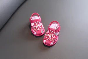 Vue détaillée de sandales roses pour bébés avec papillons décoratifs et perles