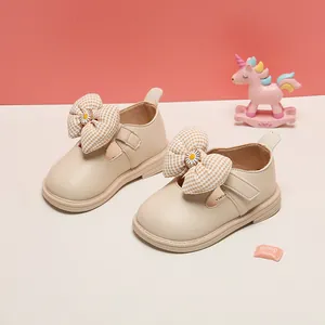 Detailed view of beige toddler princess shoes featuring a large gingham bow