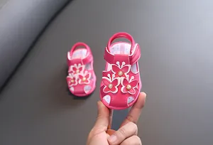Vue détaillée de sandales roses pour bébé fille avec papillons et perles pour tout-petits.