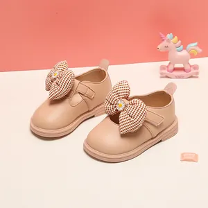 Detail of toddler girl princess shoes featuring a large houndstooth bow and soft leather.