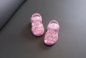 Détail de sandales roses pour bébés filles avec papillons et perles décoratives