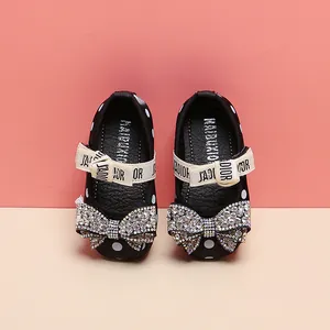 Close-up detail of toddler girl princess shoes featuring rhinestone bow and polka dot pattern
