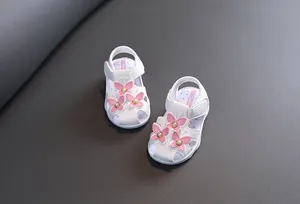 Sandales blanches bébé fille avec papillons roses, perles et semelles souples.